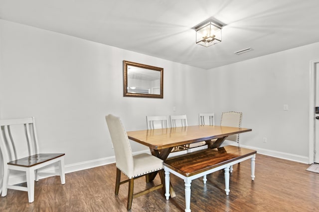 dining room featuring wood finished floors, baseboards, and a chandelier