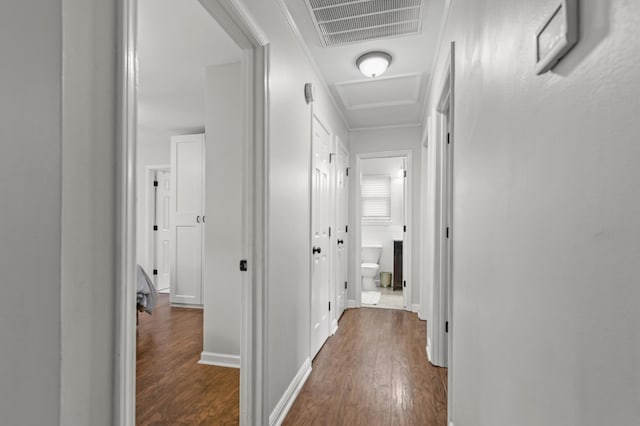 hall featuring dark wood-style floors, attic access, and baseboards