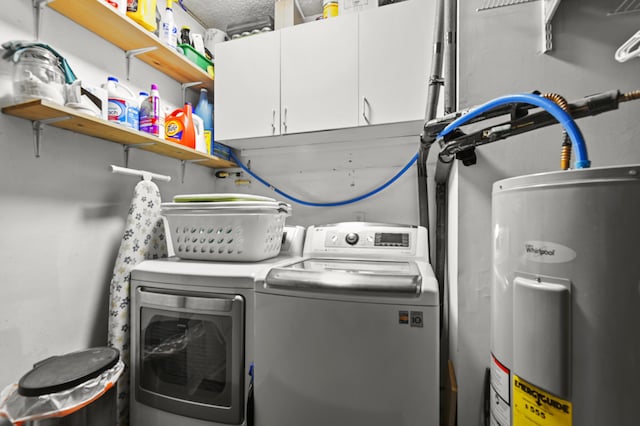 laundry room featuring cabinet space, electric water heater, and washing machine and clothes dryer