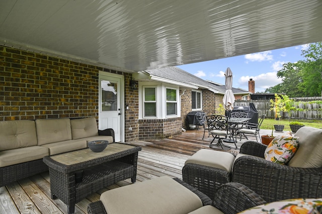 wooden deck with an outdoor hangout area, outdoor dining area, and a fenced backyard