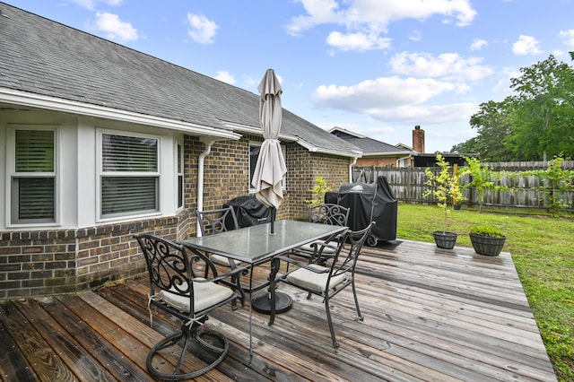 wooden terrace featuring outdoor dining area and a grill