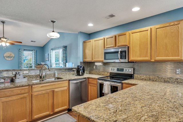 kitchen featuring stainless steel appliances, sink, pendant lighting, and kitchen peninsula