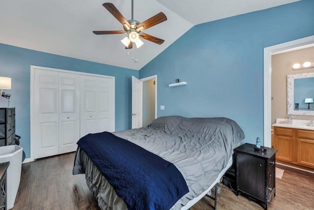 bedroom featuring lofted ceiling, dark hardwood / wood-style flooring, ceiling fan, ensuite bath, and a closet