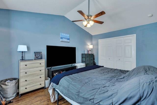 bedroom with lofted ceiling, dark wood-type flooring, ceiling fan, and a closet