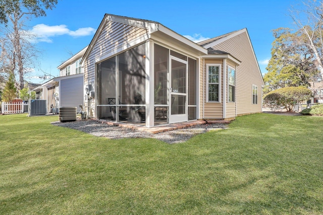 rear view of property with a yard, a sunroom, and central air condition unit