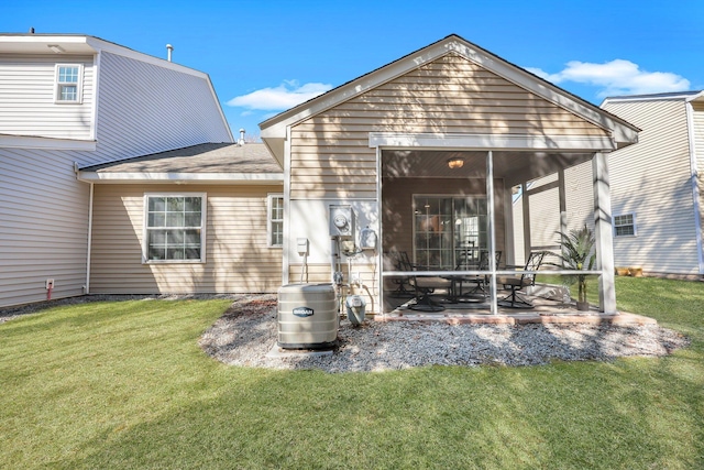 back of property with a patio area, a sunroom, and a lawn