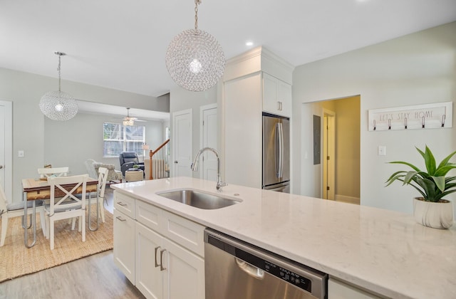2404 Fulford Ct, Mount Pleasant, SC 29466 - kitchen with stainless steel appliances, light wood finished floors, white cabinets, decorative light fixtures, and light stone counters