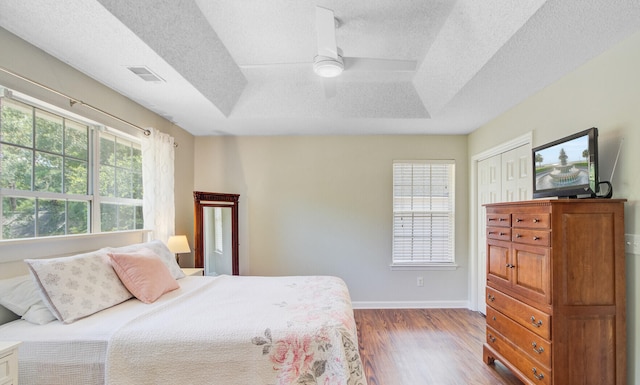 2404 Fulford Ct, Mount Pleasant, SC 29466 - bedroom featuring wood finished floors, a textured ceiling, ceiling fan, and a tray ceiling