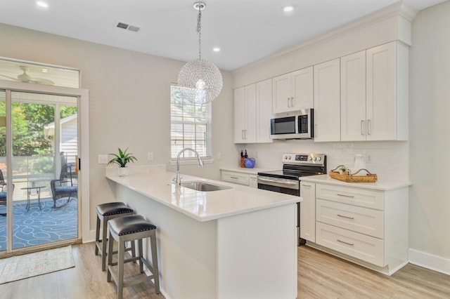 2404 Fulford Ct, Mount Pleasant, SC 29466 - kitchen with stainless steel appliances, light wood-style flooring, decorative backsplash, white cabinets, and recessed lighting