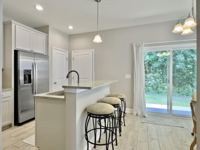 1069 Lexi Ct, Ladson, SC 29456 - kitchen featuring stainless steel fridge with ice dispenser, a sink, a chandelier, light stone countertops, and wood tiled floors