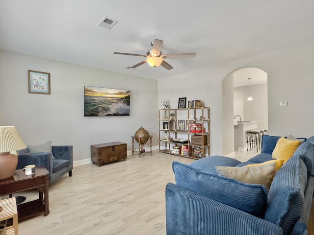 1069 Lexi Ct, Ladson, SC 29456 - living area with arched walkways, a ceiling fan, light wood-style floors, and baseboards