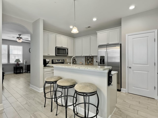 1069 Lexi Ct, Ladson, SC 29456 - kitchen featuring stainless steel appliances, a ceiling fan, white cabinets, a breakfast bar area, and recessed lighting