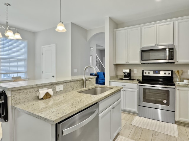 1069 Lexi Ct, Ladson, SC 29456 - kitchen featuring appliances with stainless steel finishes, a sink, a kitchen island with sink, a chandelier, and white cabinets