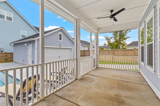 view of patio / terrace with ceiling fan, a garage, and an outbuilding