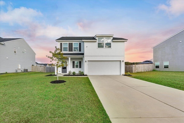 view of front property with a lawn, a garage, and central AC