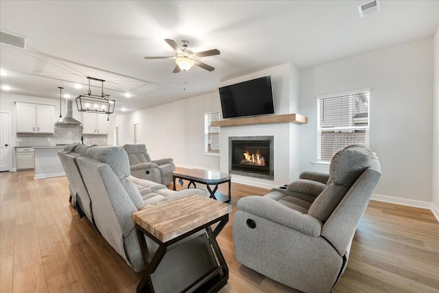 living room with light hardwood / wood-style floors and ceiling fan