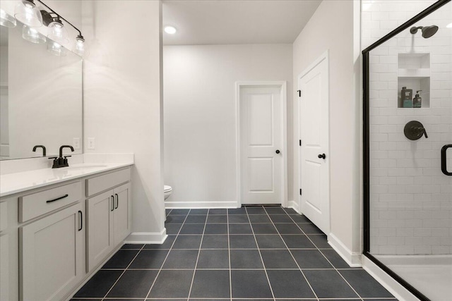 bathroom with tile patterned flooring, vanity, a shower with shower door, and toilet