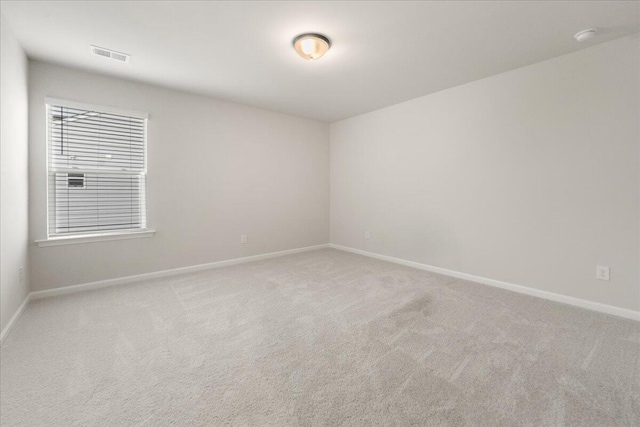 spare room featuring light colored carpet