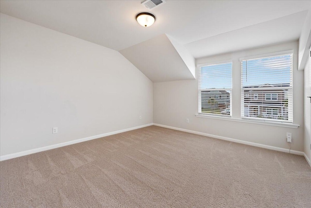 additional living space with carpet flooring and vaulted ceiling