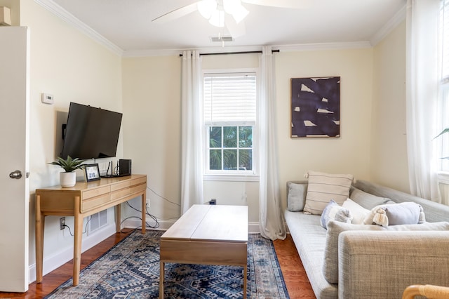 living room with dark hardwood / wood-style flooring, ceiling fan, and crown molding