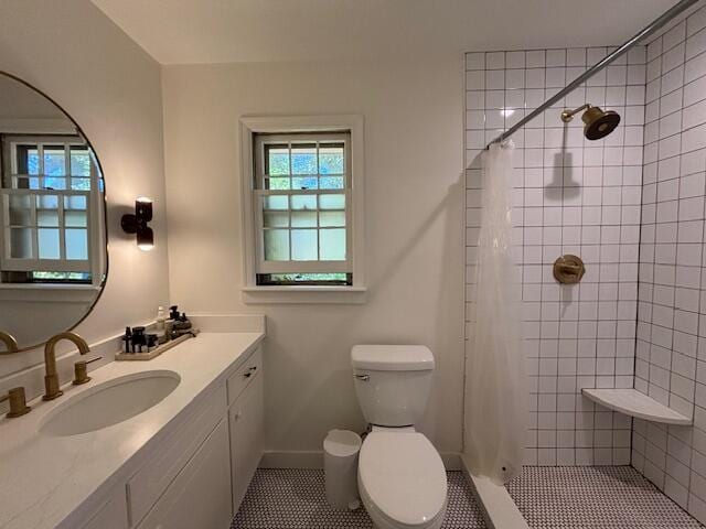full bathroom with tile patterned floors, a healthy amount of sunlight, toilet, and tiled shower