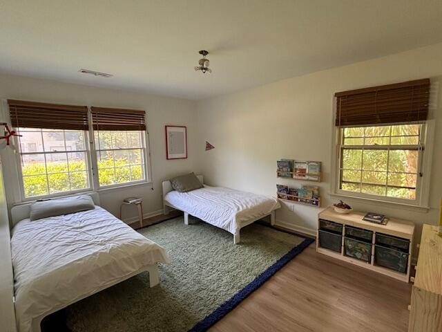 bedroom with baseboards, visible vents, and light wood-style flooring