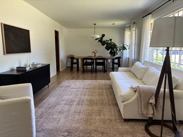 living room featuring baseboards, plenty of natural light, and wood finished floors