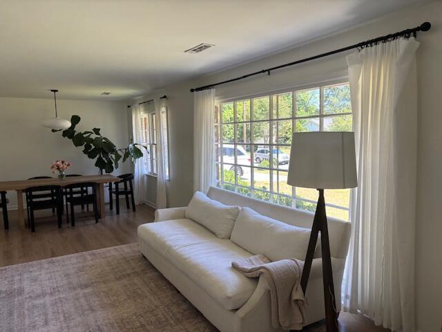 living room featuring visible vents and wood finished floors