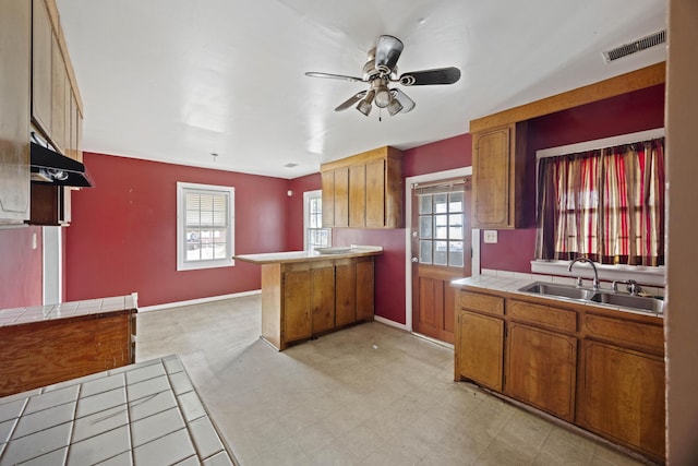 2736 Bonds Ave, North Charleston, SC 29405 - kitchen with ceiling fan, kitchen peninsula, sink, and tile countertops