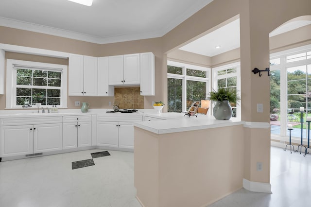 kitchen featuring decorative backsplash, white cabinets, visible vents, and plenty of natural light
