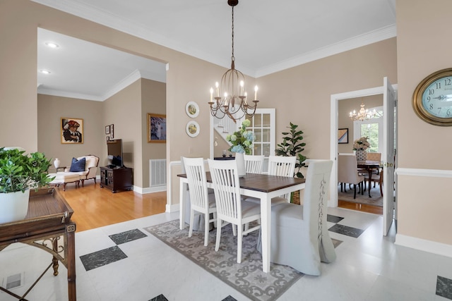 dining area with baseboards, visible vents, ornamental molding, and a chandelier