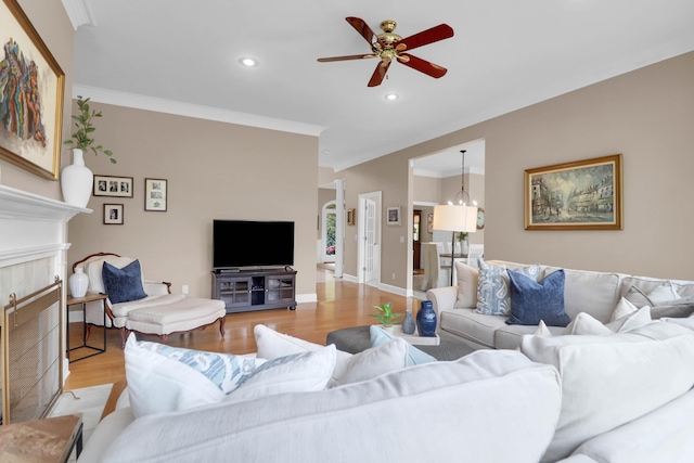 living area with ceiling fan, light wood-style flooring, recessed lighting, and crown molding