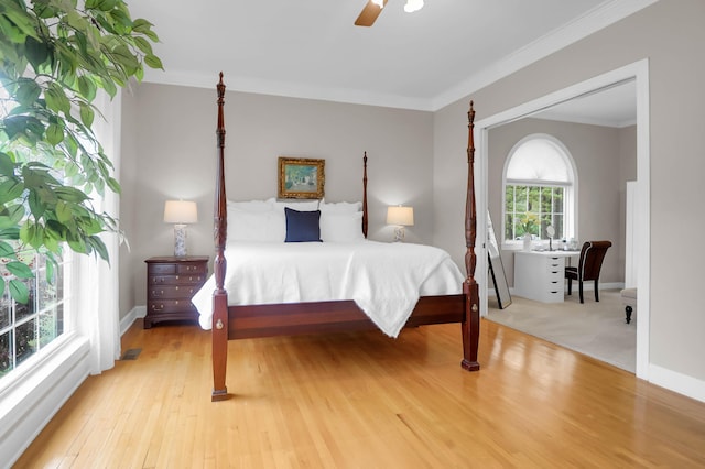 bedroom with baseboards, crown molding, wood finished floors, and ceiling fan