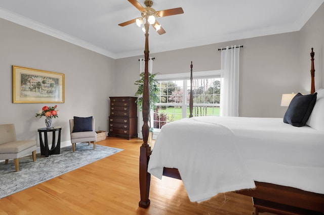 bedroom featuring ceiling fan, crown molding, and light wood finished floors