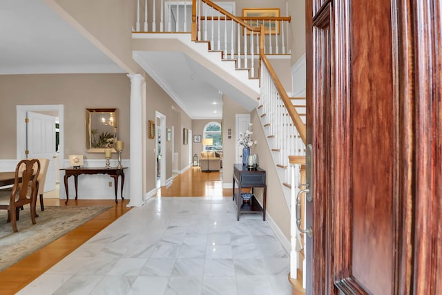 entryway featuring baseboards, stairs, ornamental molding, and a towering ceiling