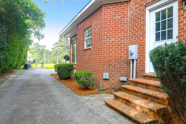 view of property exterior with brick siding and entry steps