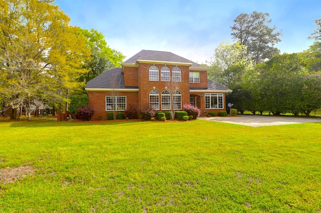 colonial house featuring brick siding and a front lawn
