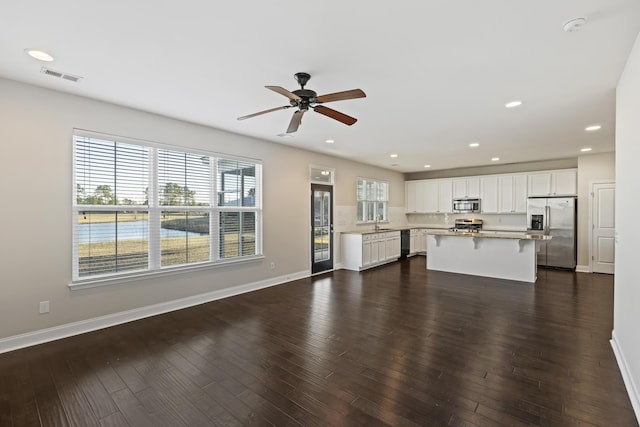 unfurnished living room featuring ceiling fan, dark hardwood / wood-style flooring, and sink