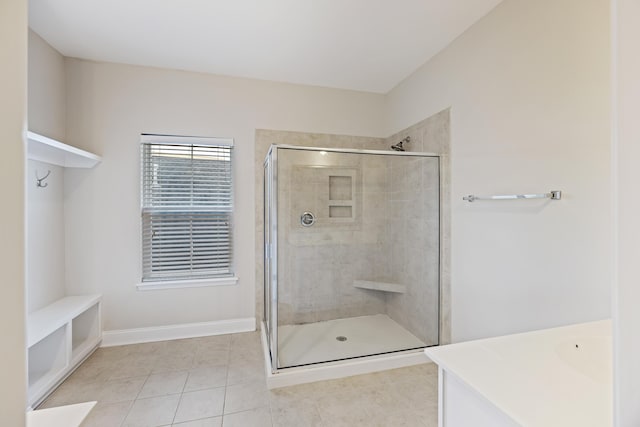 bathroom with tile patterned floors, vanity, and walk in shower