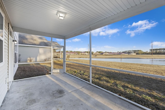 unfurnished sunroom featuring a water view