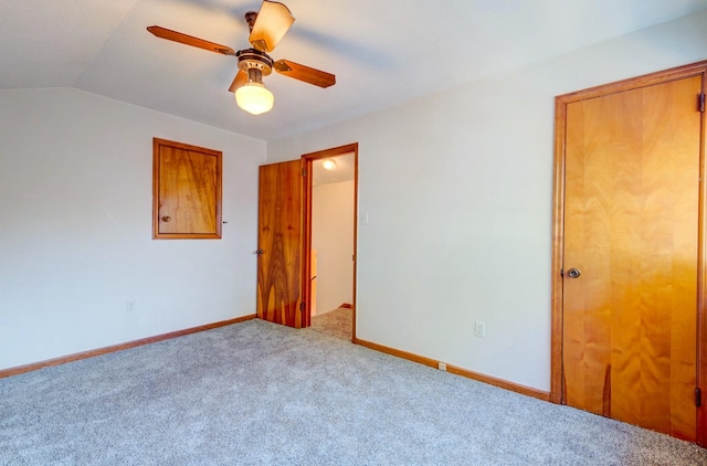 unfurnished bedroom featuring light carpet, lofted ceiling, and ceiling fan