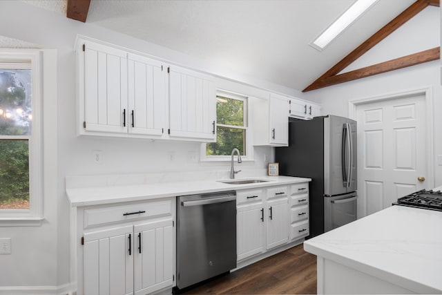 kitchen featuring white cabinets, sink, appliances with stainless steel finishes, and vaulted ceiling