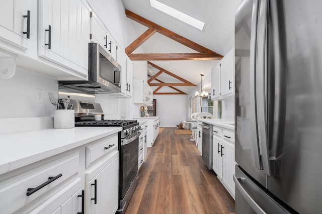 kitchen with vaulted ceiling with beams, white cabinetry, and appliances with stainless steel finishes