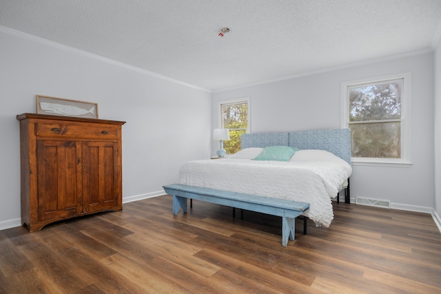 bedroom with dark hardwood / wood-style flooring, ornamental molding, and a textured ceiling