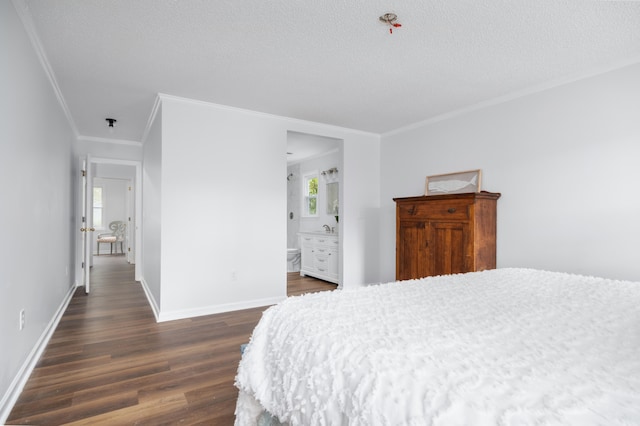 bedroom featuring ensuite bathroom, crown molding, dark wood-type flooring, and a textured ceiling