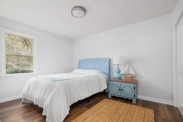 bedroom featuring a textured ceiling, dark hardwood / wood-style flooring, and a closet