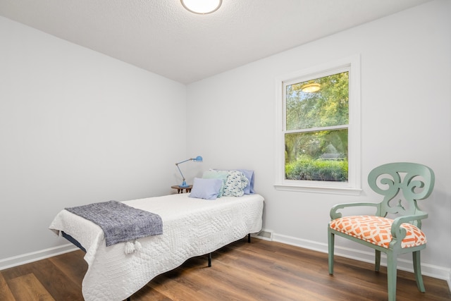 bedroom featuring dark wood-type flooring and multiple windows