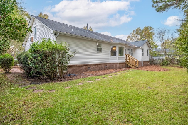 rear view of house featuring a lawn