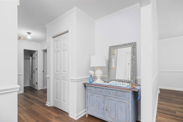 hall with a textured ceiling, dark hardwood / wood-style floors, and crown molding