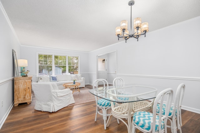 dining room featuring a textured ceiling, a notable chandelier, dark hardwood / wood-style flooring, and crown molding